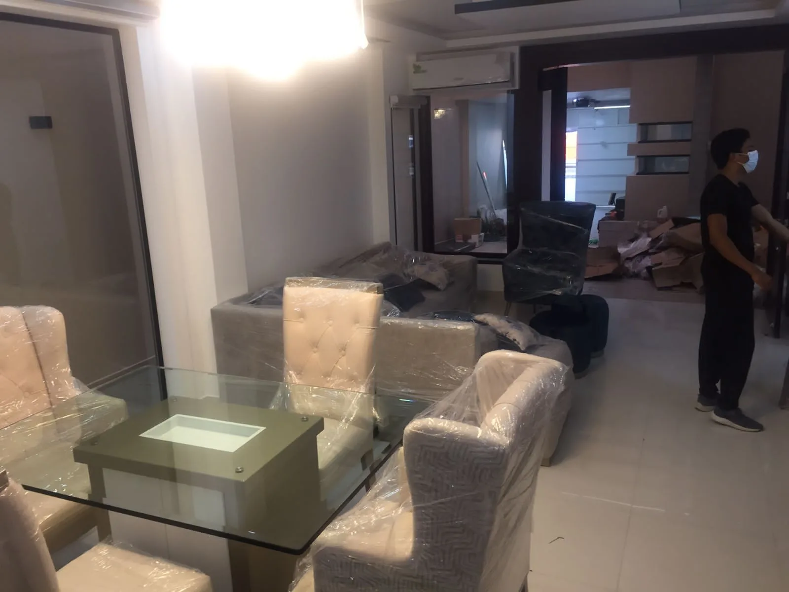 Comedor escena de mudanza/entrega con sillas y sofás envueltos en plástico