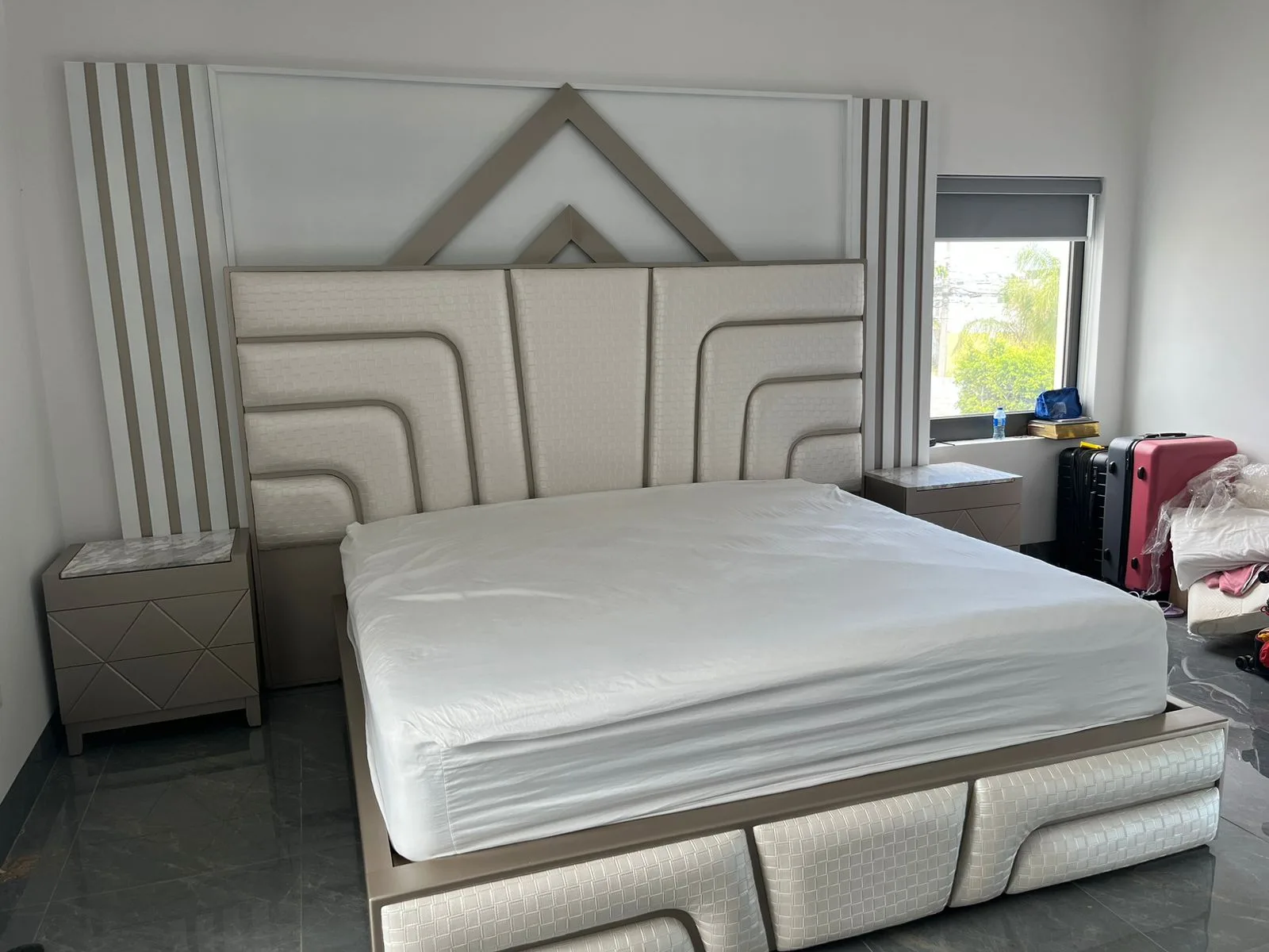 Cabecera de cama con textura tejida en canales curvos y remate metálico triangular (estilo art-decó)