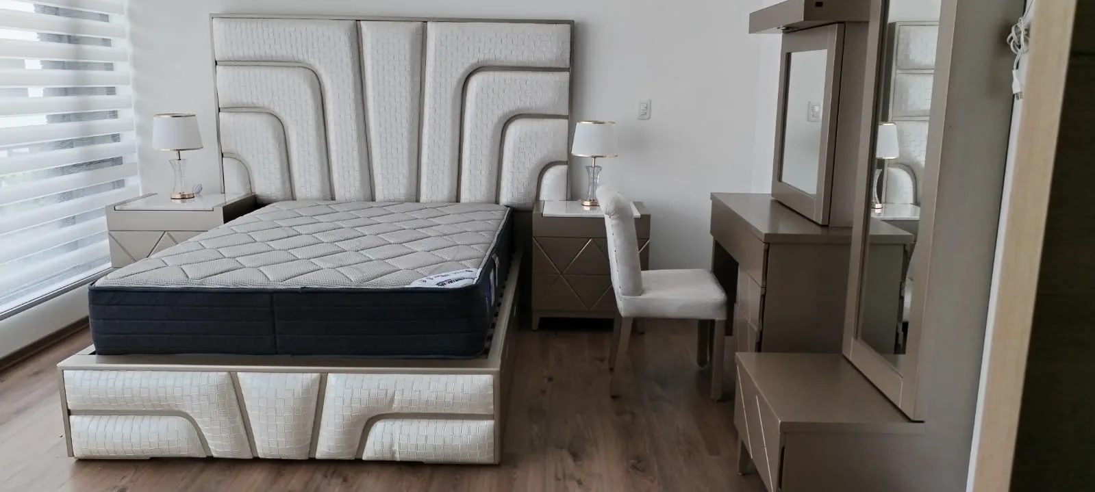 Cabecera de cama con textura tejida en canales curvos y remate metálico triangular (estilo art-decó)