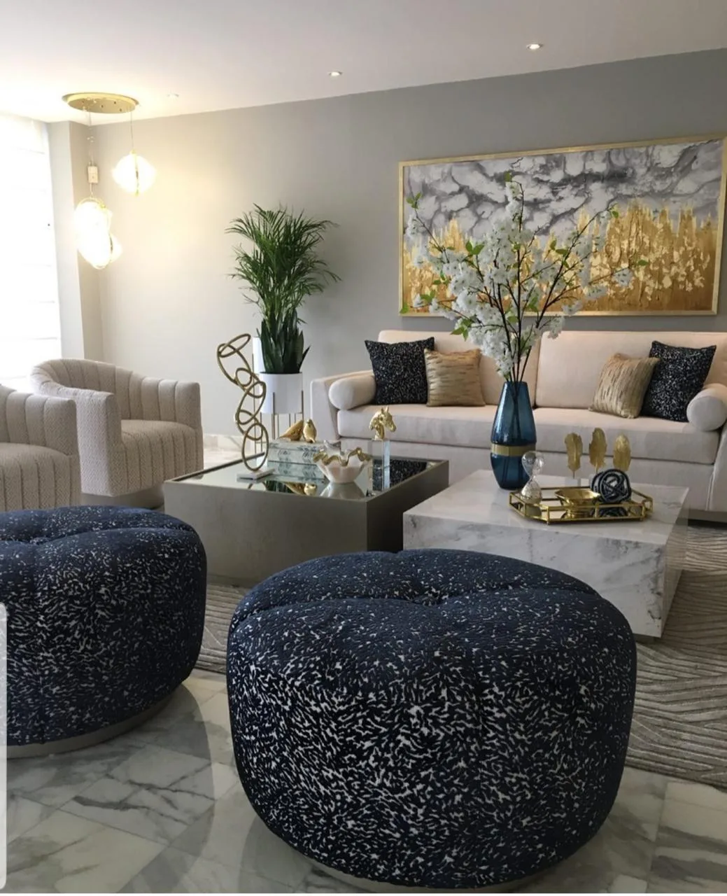 Sala a medida — tapizado crema con pufs azules y dorado
